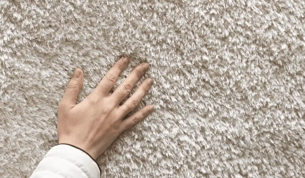 Hand touching soft carpet.